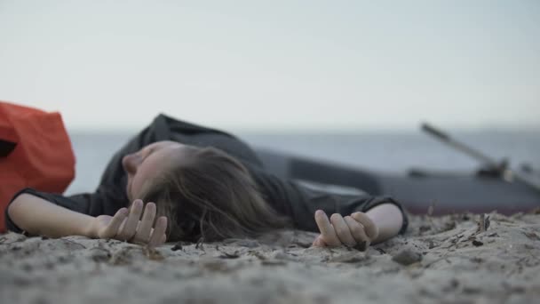 Bewusteloze vrouw liggend aan de kust, verdronken zwemmer, slachtoffer van schipbreuk — Stockvideo
