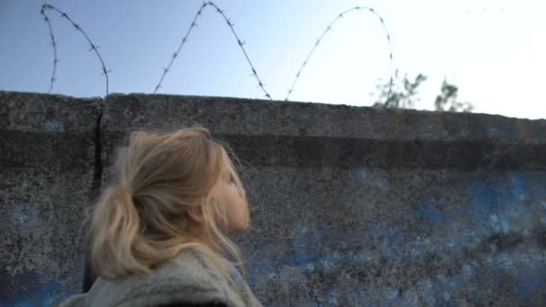 Piccola ragazza rifugiata guardando filo spinato, sognando nuova patria, migrazione — Video Stock