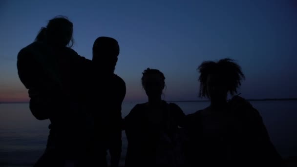 Silhouette of family hugging against night sea background, unity in difficulties — ストック動画