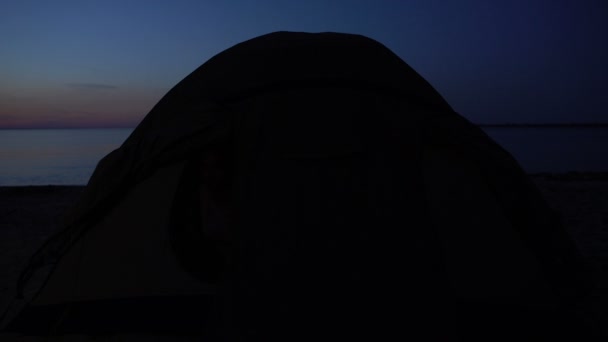 Biracial teen dívka skrývající se ve stanu, když svítí baterka, uprchlický tábor na pobřeží — Stock video