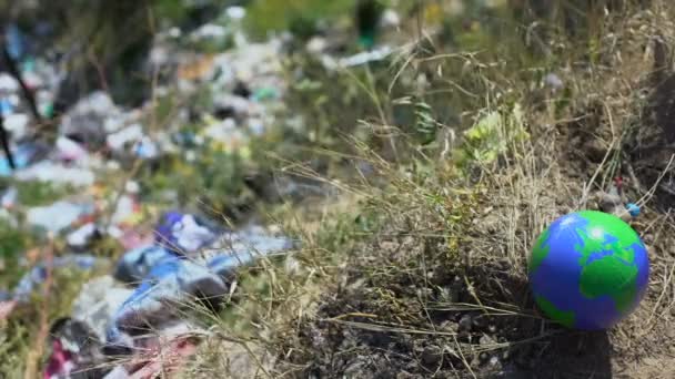 Aardbol nabij open dumping, achtergelaten door mensen in het bos, ecologische vervuiling — Stockvideo