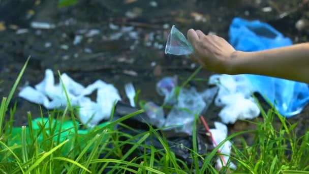 Mão jogando tampa de plástico no lago sujo, pessoas irresponsáveis impacto na vida selvagem — Vídeo de Stock