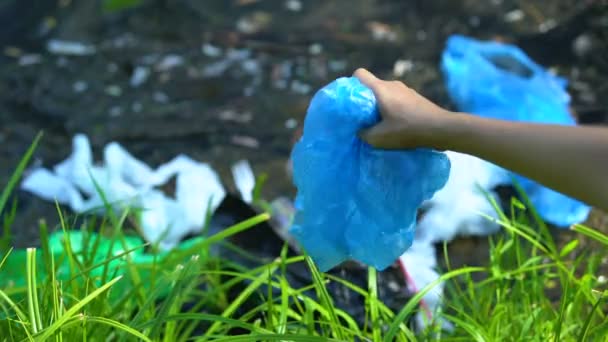 Человек бросает пластиковый пакет в грязное озеро, безответственные люди влияют на природу — стоковое видео