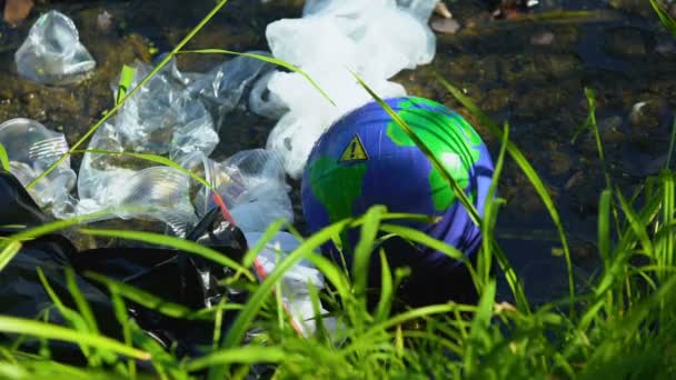 Руки в перчатках, захватывающих земной шар с предупреждающим знаком загрязненного озера, экологии — стоковое видео