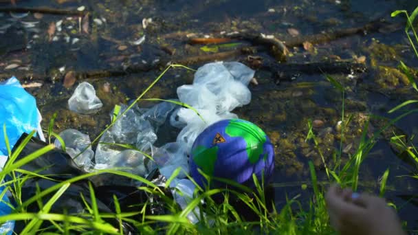 Mujer tomando globo terráqueo con señal cruzada de lago contaminado, ecovoluntariado — Vídeo de stock