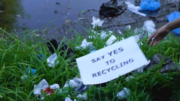 Persoon die karton met "ja" zegt tegen recyclingzin bij open dumping — Stockvideo