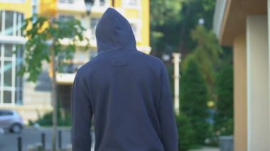 Kapüşonlu üzgün adam yavaşça yürüyordu. Geleceği düşünüyordu, sorunları vardı.