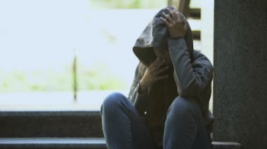 Genç, üzgün, sigara içen kadın merdivenlerde yalnız, depresyon ve sorun yaşıyor.