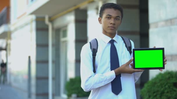 Estudiante negro afroamericano inteligente mostrando tableta de pantalla verde en la cámara, aplicación — Vídeos de Stock