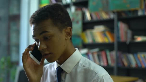 Smartphone intelligent masculin parlant au lycée à la bibliothèque de l'académie, communication — Video