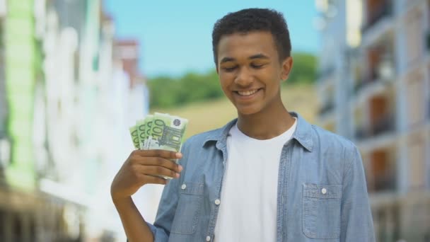 Masculino joven mestizo contento mostrando racimo de euros y sonriente, financiación del primer sueldo — Vídeos de Stock