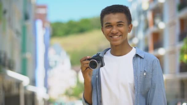 Έφηβος άνδρας φωτογράφος με φωτογραφική μηχανή που κρατάει ευρώ και χαμογελά πρώτο εισόδημα, χόμπι — Αρχείο Βίντεο