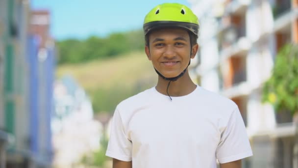 Волнующий афро-американец-подросток в защитном шлеме, улыбающийся, велосипедное хобби — стоковое видео