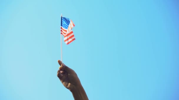 Persona che tiene la bandiera degli Stati Uniti sullo sfondo del cielo, patriottismo, libertà, primo piano — Video Stock