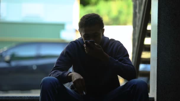 Adolescente nervoso fumando cigarro e brigando no telefone com a namorada — Vídeo de Stock