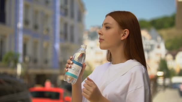 Mooie gezonde vrouw drinken zoet stilstaand water op straat, verfrissing — Stockvideo