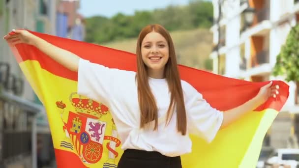 Stolze fröhliche weibliche Teenager schwenken spanische Flagge und lächeln in die Kamera, Patriotismus — Stockvideo