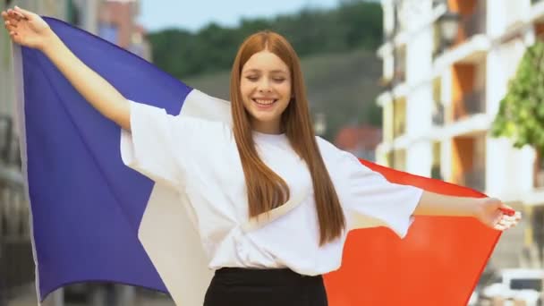 Joyful tiener meisje zwaaien vlag van Frankrijk en glimlachen, patriottisme en nationale feest — Stockvideo