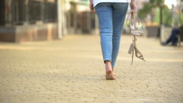 Barefoot girl walking down street holding in hands high-heeled sandals, freedom — Stock Video