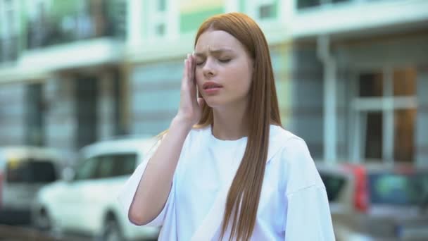 Nastoletnia dziewczyna masująca świątynie, uczucie bólu głowy, życie w hałaśliwym mieście, migrena — Wideo stockowe