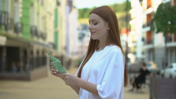 Muchacha adolescente excitada sosteniendo billetes en euros de pie en la calle, primer salario — Vídeo de stock