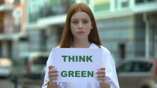 Подумайте зеленый знак в руках девушки, подростки кампании против обезлесения — стоковое видео