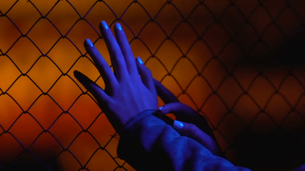 Female hands slowly falling down from wire fence, woman losing consciousness — Stock Video