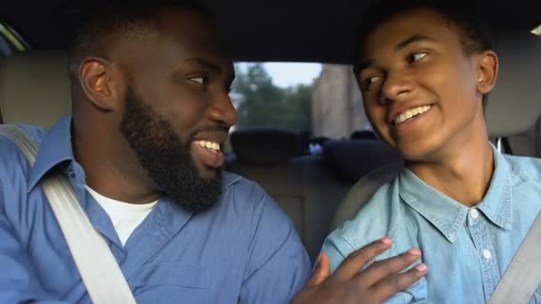 Glücklicher afroamerikanischer Mann ermutigt lächelnden Teenager auf dem Fahrersitz, Errungenschaft — Stockvideo