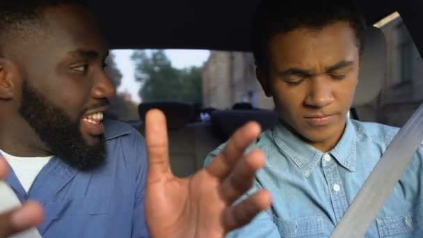 Ångestfylld afro-amerikan skriker och ger en örfil till tonåringen på förarsätet — Stockvideo