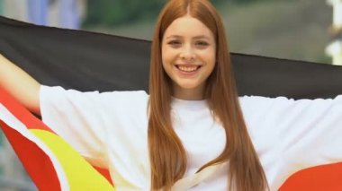 Alman bayrağı taşıyan genç bir kadının hava öpücüğü göndermesine sevindim. Spor müsabakası.