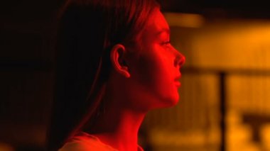 Alacakaranlıkta güzel bir genç kadın, gece kulübünde dinlenen bir kadın, barda bekliyor.