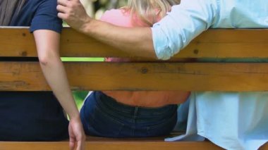 Genç bir adam, kız arkadaşının ihaneti sırasında tezgah arasında el ele tutuşuyor.