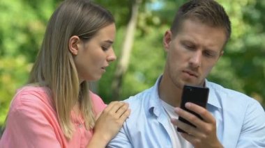 Suçlu kız arkadaş cep telefonuyla kayan rahatsız bir erkekle barışmaya çalışıyor.