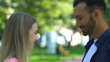 Bir buket lale taşıyan bir adam kız arkadaşının başka bir adamla flört edişini izliyor.