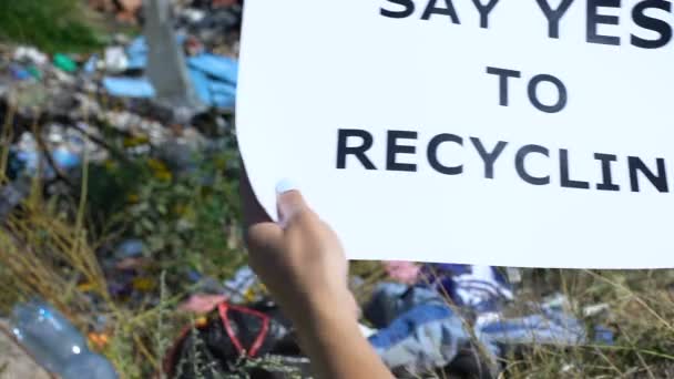 Zgódź się na recykling, wysypisko śmieci w tle, wolontariat apelujący do ludzi — Wideo stockowe