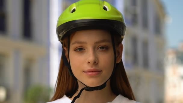 Mooie vrouwelijke tiener in fiets helm glimlachen op de camera, gezonde activiteit, sport — Stockvideo