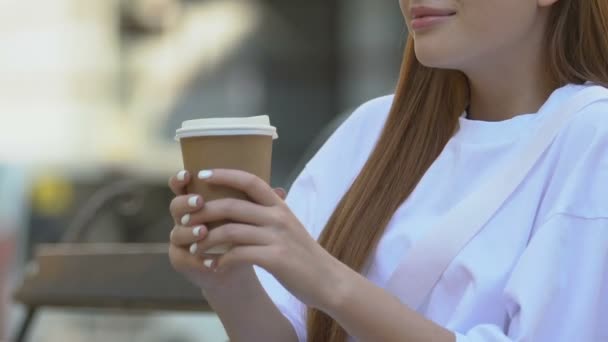Joven mujer ardiendo labios mientras bebe té caliente al aire libre, llevar comida rápida — Vídeos de Stock