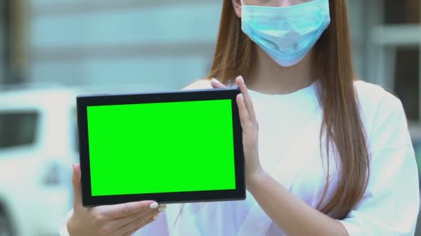 Mujer máscara protectora celebración de tableta de pantalla verde, contaminación del aire, virus epidémico — Vídeo de stock