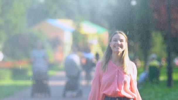 Веселая женщина тысячелетия наслаждается фонтанными капельками в парке, детским настроением, радостью — стоковое видео