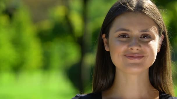 Jong mooi vrouw oprecht glimlachen op camera in park vrouwen gezondheid vitaminen — Stockvideo