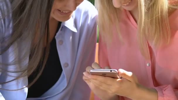 Twee beste vrouwelijke vrienden roddelen over social network foto 's mobiele applicatie — Stockvideo