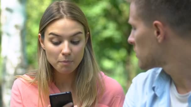 Frau streitet sich mit Freund, liest private Nachrichten auf seinem Handy, eifersüchtig — Stockvideo