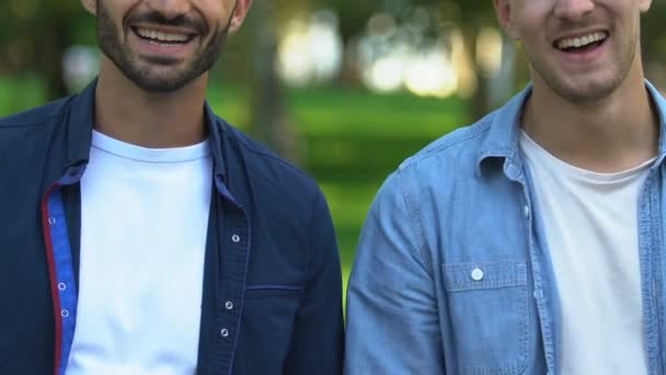 Mejores amigos masculinos sonriendo a la cámara haciendo golpe de puño, amistad real, primer plano — Vídeos de Stock