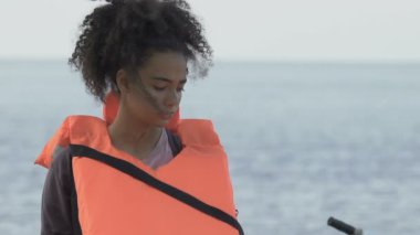 Gemide can yeleği tutan üzgün Afro-Amerikalı bir kız, gemi kazasından sonra ailesi kaybolmuş.