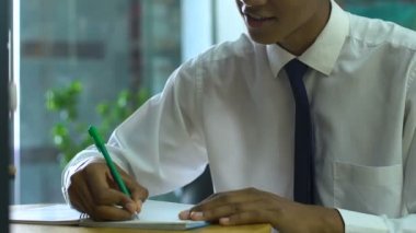 Afro-Amerikalı okul çocuğu kompozisyon yazıyor ilham verici görünüyor, ilginç bir ev ödevi.