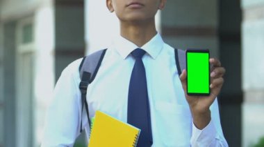 Cep telefonu gösteren ciddi bir öğrenci, özel okula kayıt için uygulamalar