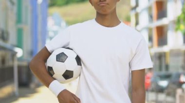 Futbol topu tutan kendine güvenen sporcu, genç futbolcu, antrenmanlar