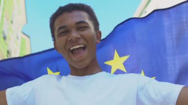 Mutlu Afro-Amerikalı genç erkek Eu bayrağı sallıyor, politik reform desteği