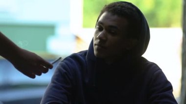 El yapımı sigara teklif eden Afro-Amerikan erkek ergen, zararlı etki, sigara