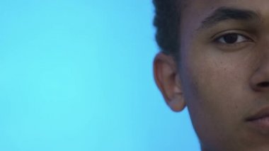 Üzgün Afro-Amerikalı bir gencin yarım yüzü kameraya bakıyor, mesaj için şablon yapıyor.